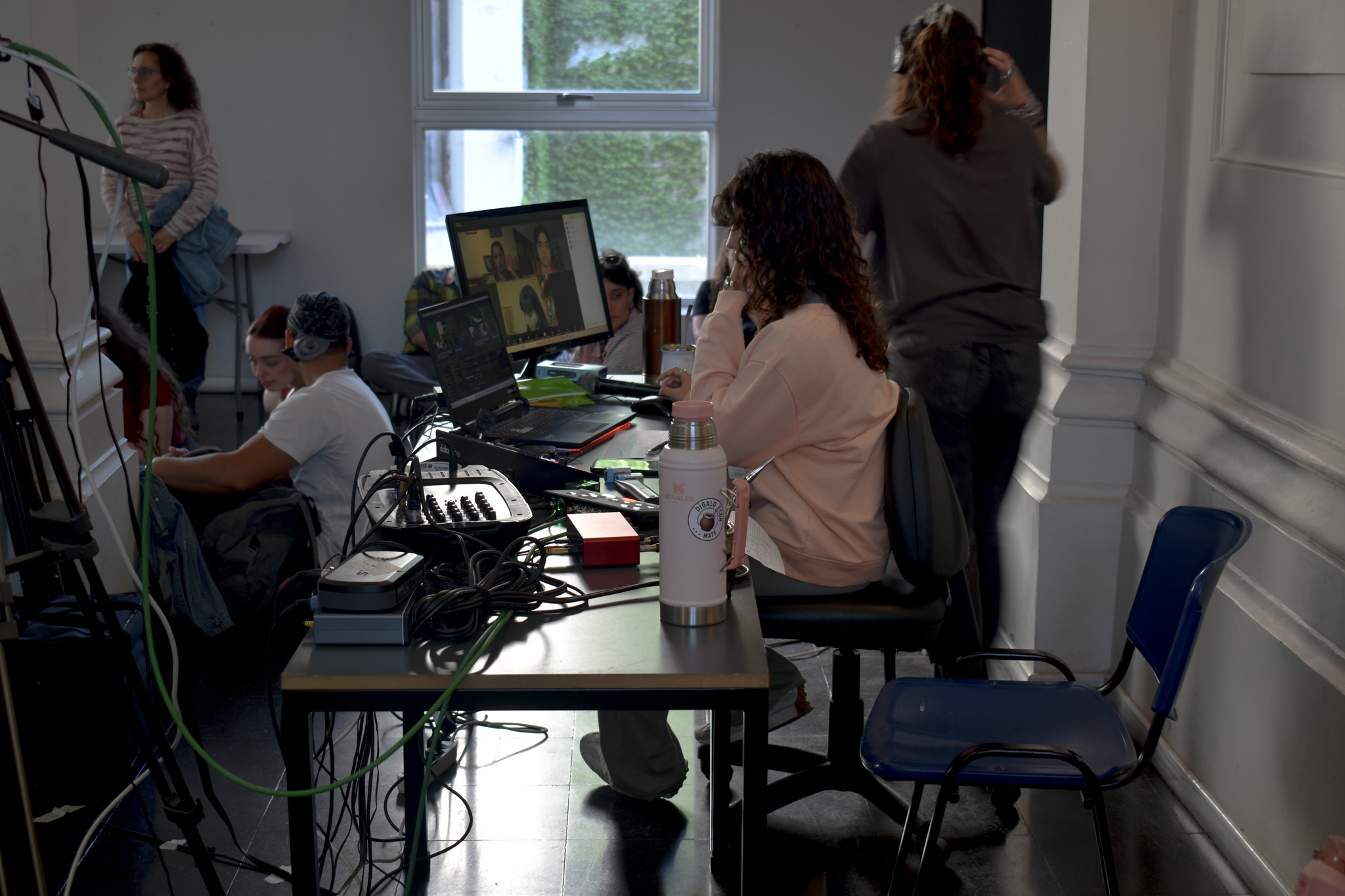 Una docente sentada fente a una computado,ra trabajando